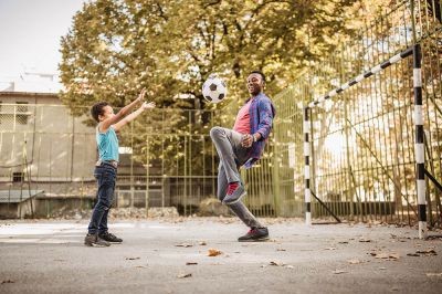 Father-and-son-playing-soccer-outdoors