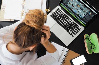 Showing-stress-employee-bent-over-computer