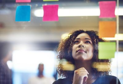 Woman-brainstorming-with-postit-notes-on-wall